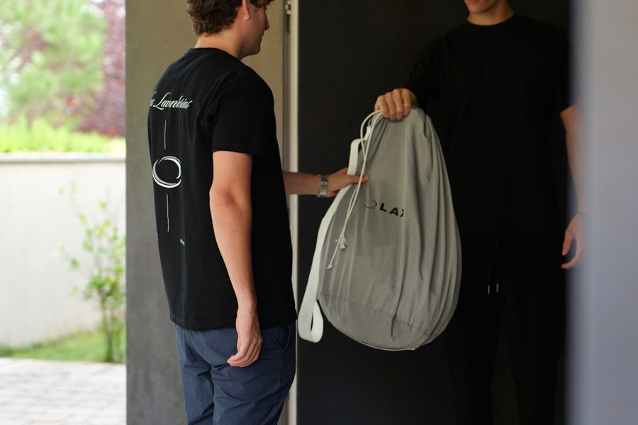 Un repartidor de LAX recoge una bolsa de ropa en la puerta de casa